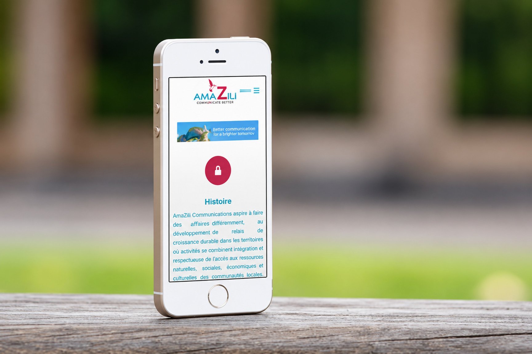 Le site d’AmaZili affiché sur un téléphone, posé sur une table en bois
