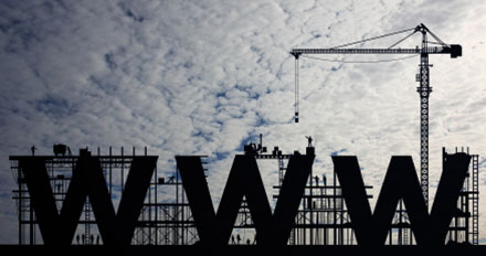 Un site web en chantier : les lettres WWW entre échafaudages et grue